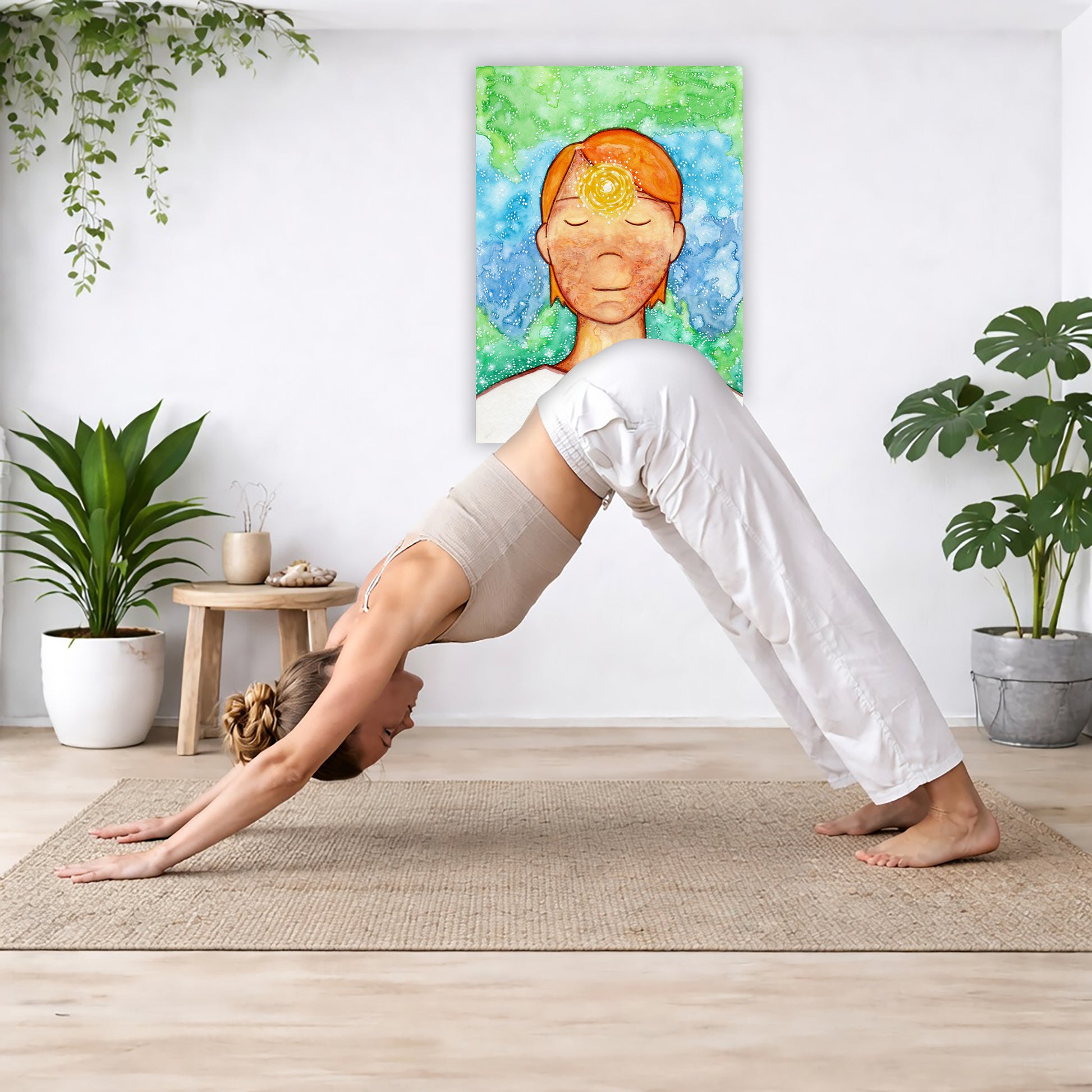 Man meditating with his brow chakra glowing canvas print.  The poster is in the center of the living room wall. Below the poster a woman is doing the yoga posture downward facing dog on a yoga mat.