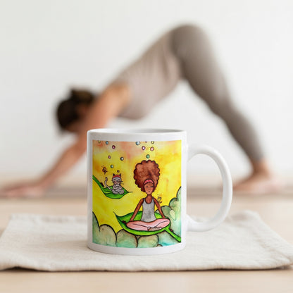 Woman and cat sitting peacefully on leaves in meditation, nature-inspired mindfulness scene representing calm, balance and connection, printed on a spiritual coffee mug. The mug is in front of a woman doing the yoga posture downward facing dog.