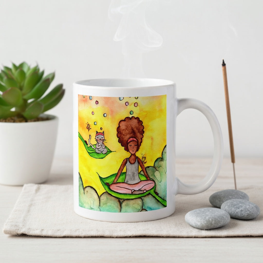 Woman and cat sitting peacefully on leaves in meditation, nature-inspired mindfulness scene representing calm, balance and connection, printed on a spiritual coffee mug. The mug is on a cloth mat. Beside the mug are meditation stones. Behind the mug incense and candles are burning.