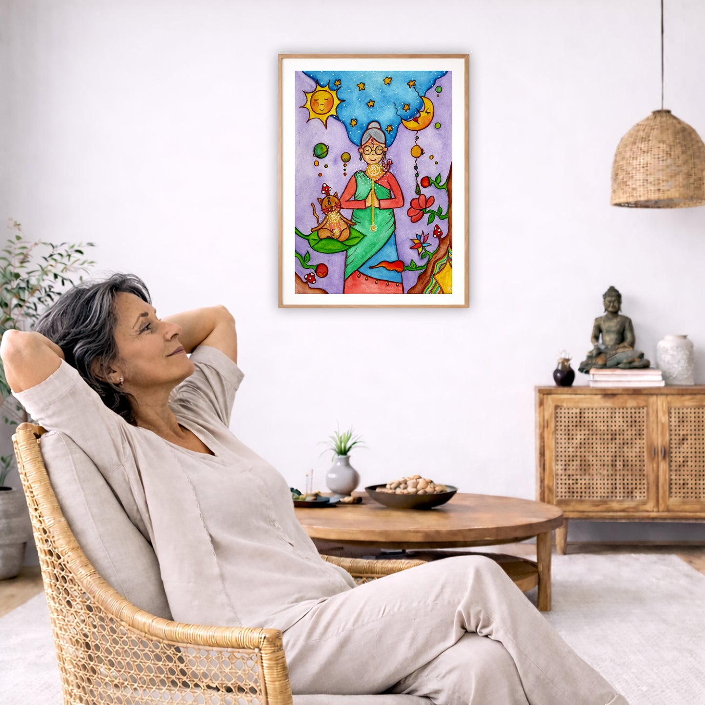Poster of a woman's throat chakra energy glowing.  The poster is framed and is in the center of the living room wall. To the left a woman is relaxing in her chair with her hands behind her head. There is a small coffee table beside her with a bowl of walnuts, incense and a small green plant. On the right side of the room is a cabinet with a Buddha statue, books and an urn on it. To the left is a green floor plant.
