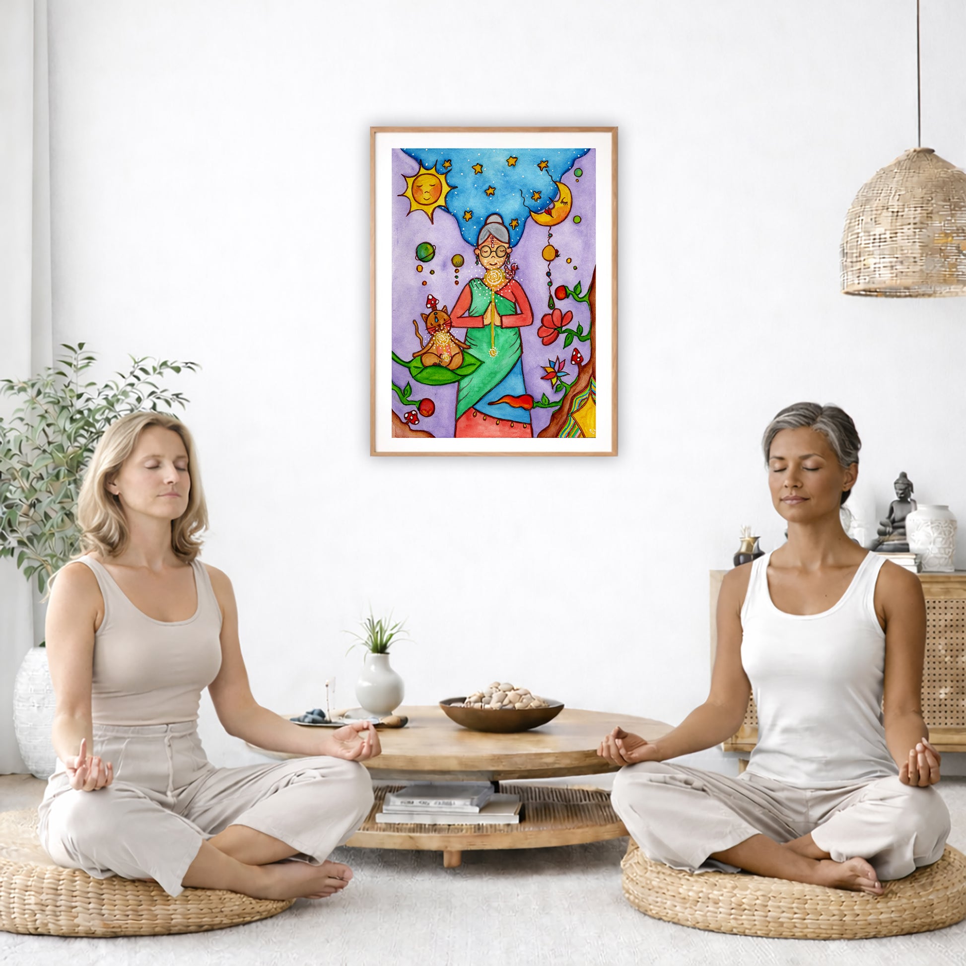 Poster of a woman's throat chakra energy glowing.  The poster is in the center of the living room wall. Two women are sitting on wicker pillows meditating. Behind them is a small round coffee table with incense, a green potted plant and a bowl of shells. There is a potted plant to the left and a Buddha statue and a vase to the right. 