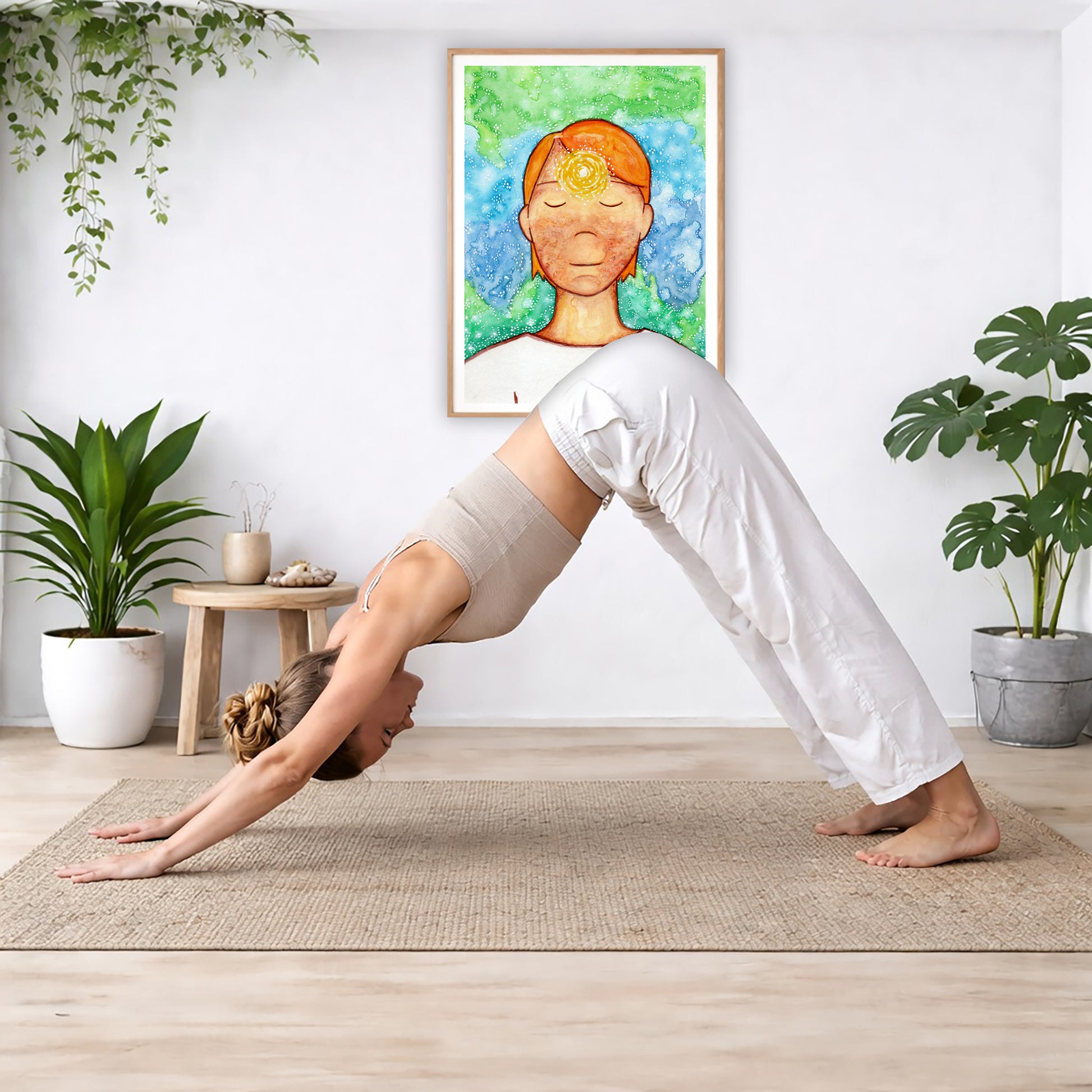 Poster of a man with a glowing brow chakra.  The poster is in the center of the living room wall. Below the poster a woman is doing the yoga posture downward facing dog on a yoga mat.