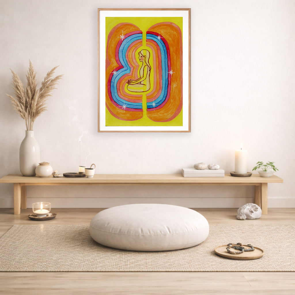 This poster showcases the beautiful, layered colors of the human aura.  The poster is framed and is in the center of the living room wall. Below the poster is a bench with incense, candles and meditation stones on it. There is also a small green potted plant and a vase with dry flora in it. There is a mat on the floor with a pillow, candle and prayer beads on it.
