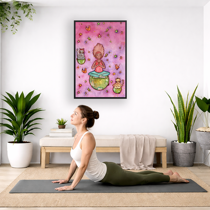 Poster of a woman and her cats meditating atop their own personal worlds with a pink background.  The poster is hanging on the wall. A woman on her yoga mat is doing the cobra pose in front of the poster. There is a potted plant, a hanging plant and a basket of cloth material on the left side. On the right side of her is a small cabinet books and a dry plant. There is also a floor plant on the right side.