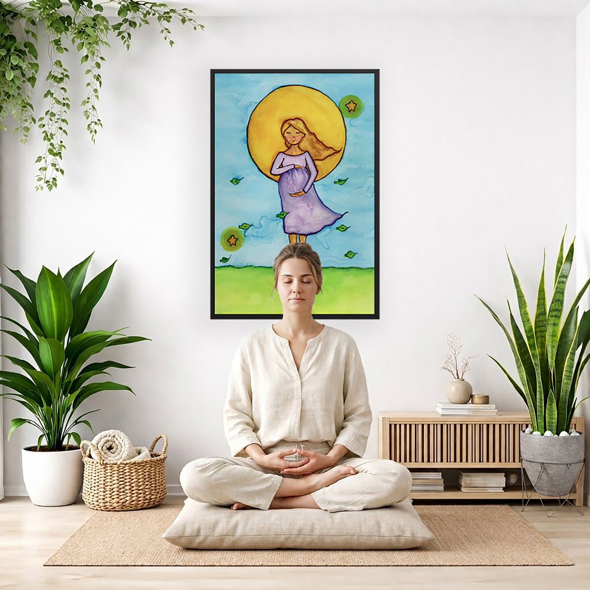 Woman standing in meditation under a bright sun with soft blue sky background, framed watercolor print.  The poster is framed and is in the center of the living room wall. There is a woman meditating facing away from the wall. Behind her is a coffee table . There are potted plants on the right and left side of the background. 