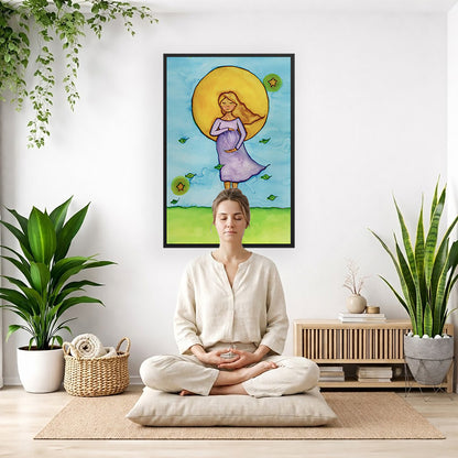 Woman standing in meditation under a bright sun with soft blue sky background, framed watercolor print.  The poster is framed and is in the center of the living room wall. There is a woman meditating facing away from the wall. Behind her is a coffee table . There are potted plants on the right and left side of the background. 