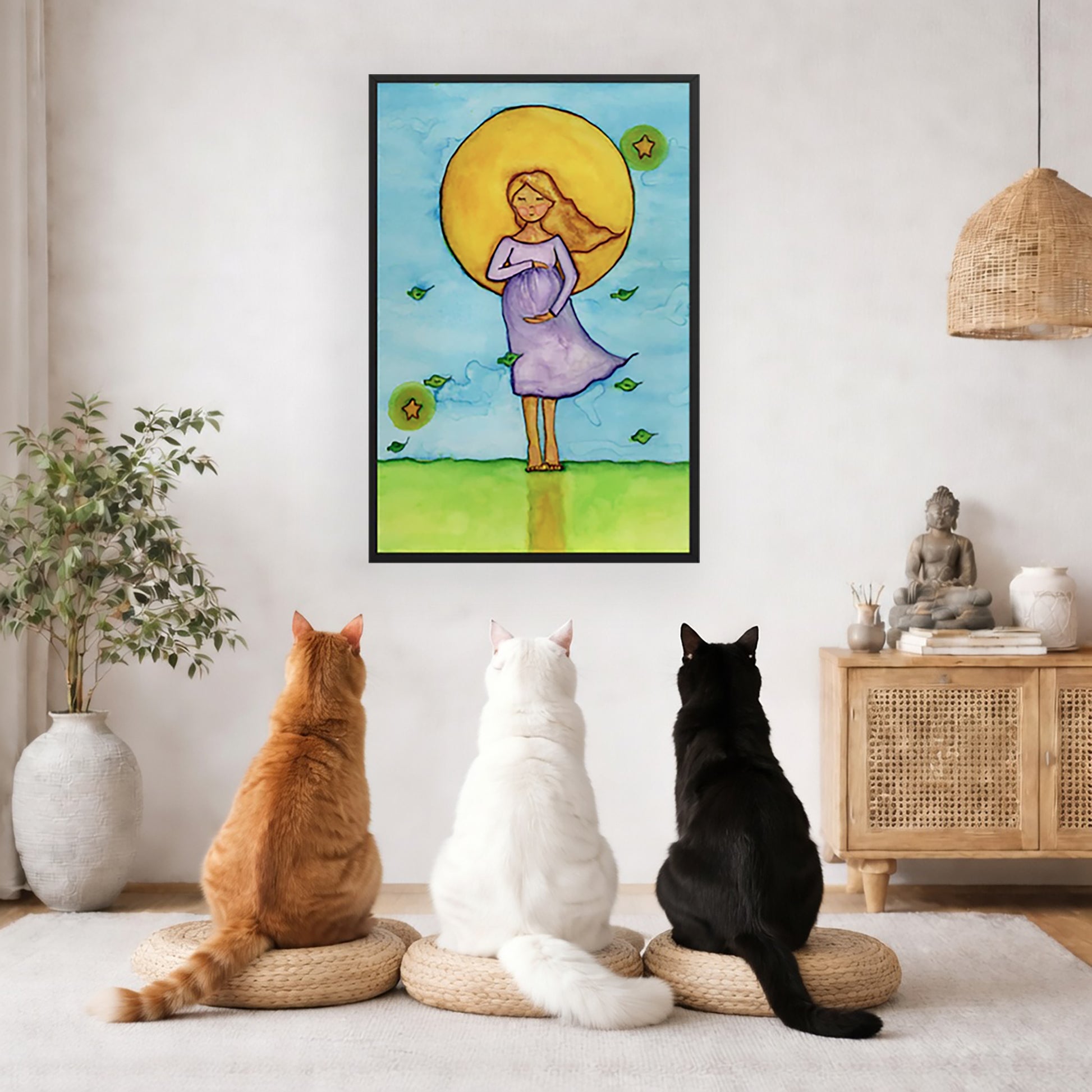 Woman standing in meditation under a bright sun with soft blue sky background, framed watercolor print. The poster framed is hanging on the wall. Three cats are staring up at the poster, orange, white and black. There is a potted plant on the left side and a cabinet with a Buddha statue, books and incense on the right side.
