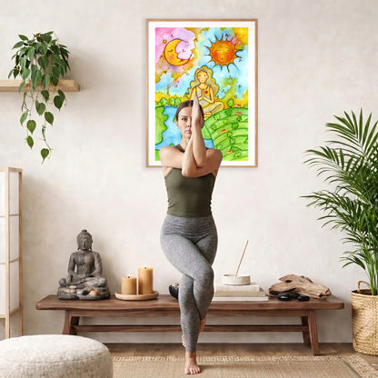 Poster of a woman meditating beneath the sun and moon cosmic design.  The poster is framed and is in the center of the living room wall. A woman is doing a sitting forward bend on her yoga mat. There is a coffee table below the poster with burning candles, incense, a Buddha statue and a big piece of driftwood.
