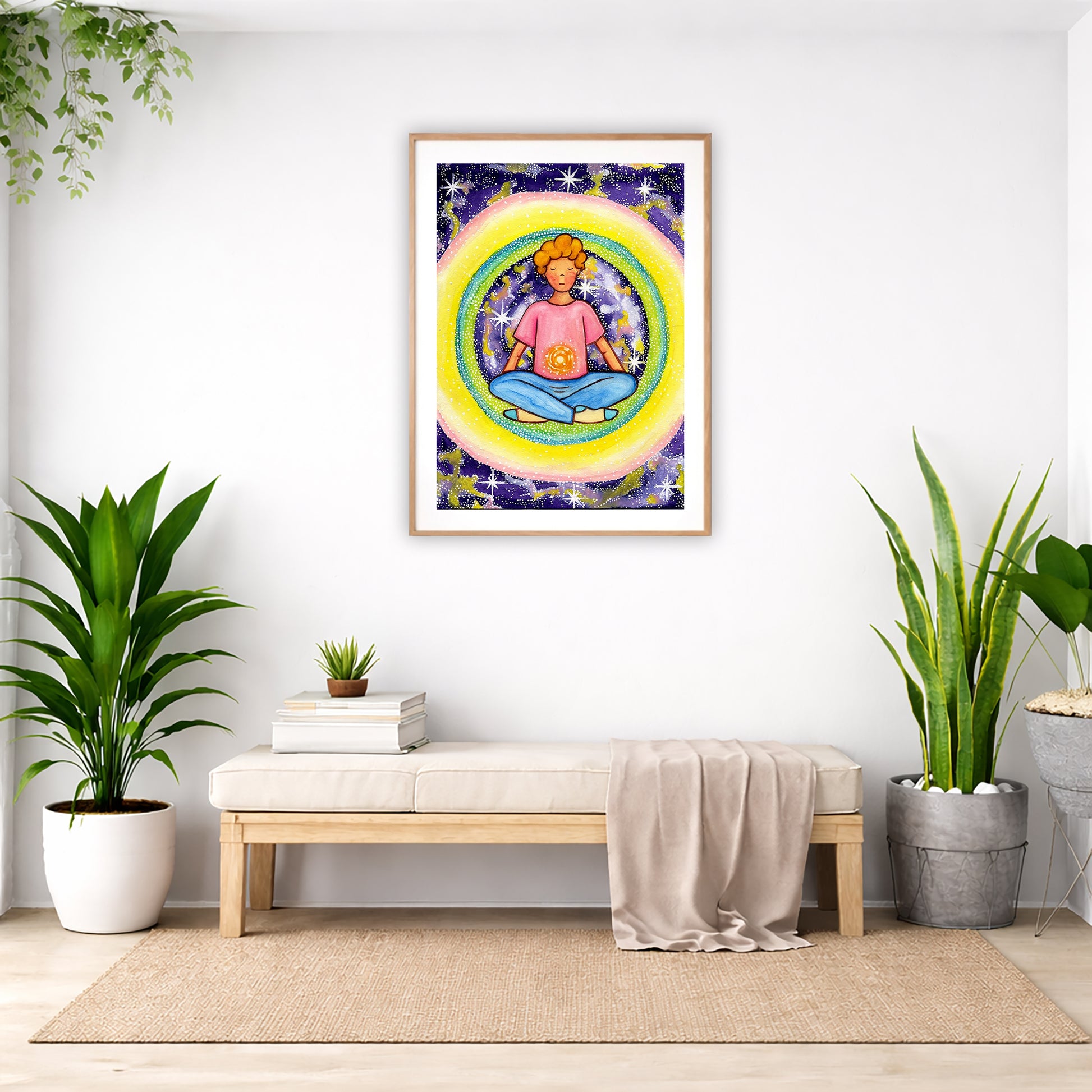 Poster of a young man meditating with his solar plexus glowing. Surrounding him is his colorful aura. The poster is in the center of the living room wall. Below the poster is a padded bench. On the bench is a pile of books and a small green potted plant. There is a silk sheet draped over the bench. There is a green hanging plant and floor plant on the left. There are two floor plants on the right.