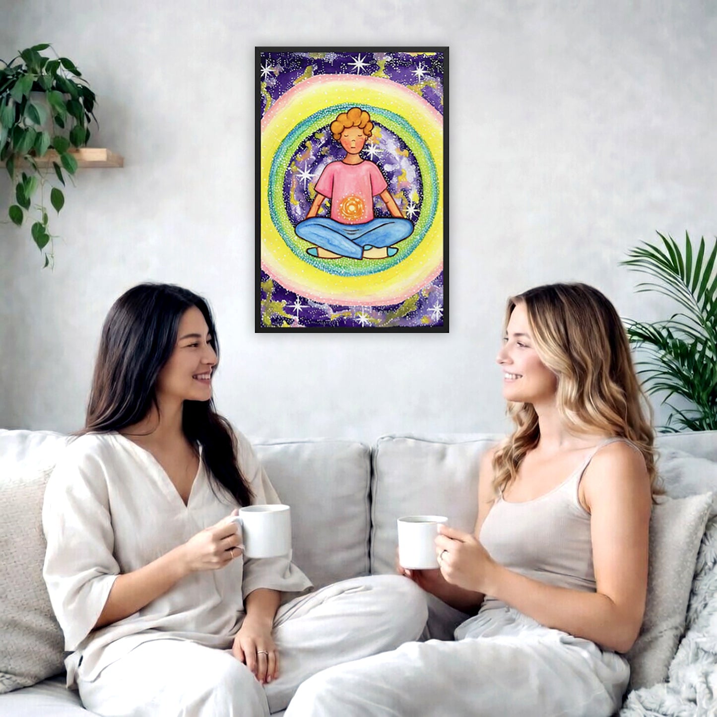 Framed poster of a young man meditating with his solar plexus glowing. He is basking in his colorful aura.  The poster is in the center of the living room wall. Two female friends are having tea, grapes and cookies on a coffee table in front of the poster. On the left there is a green potted plant and to the right there is a hanging lamp.
