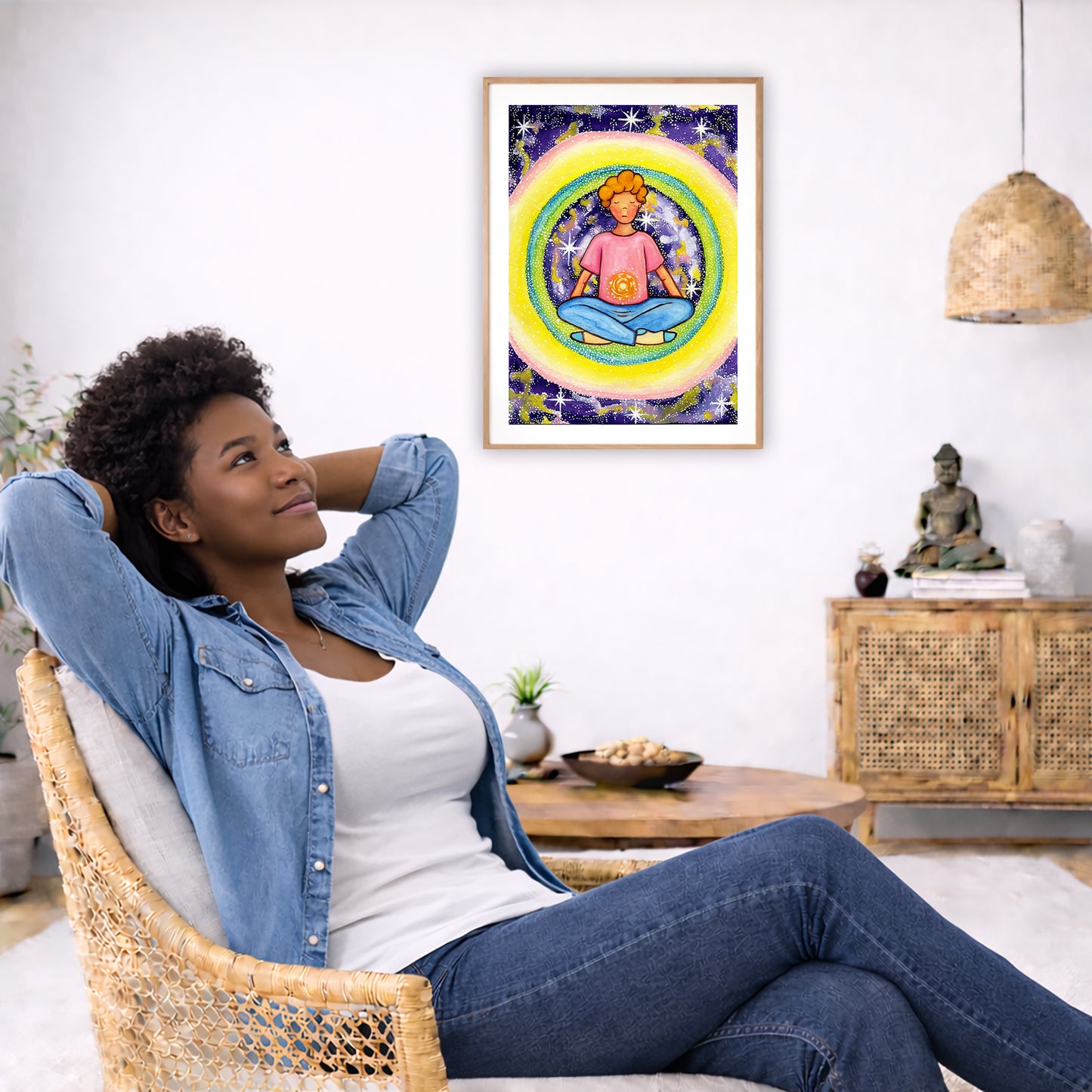 Poster of a young man meditating with his solar plexus glowing. Surrounding him is his colorful aura.  The poster is in the center of the living room wall. To the left a woman is relaxing in her chair with her hands behind her head. There is a small coffee table beside her with a bowl of walnuts, incense and a small green plant. On the right side of the room is a cabinet with a Buddha statue, books and an urn on it. To the left is a green floor plant.
