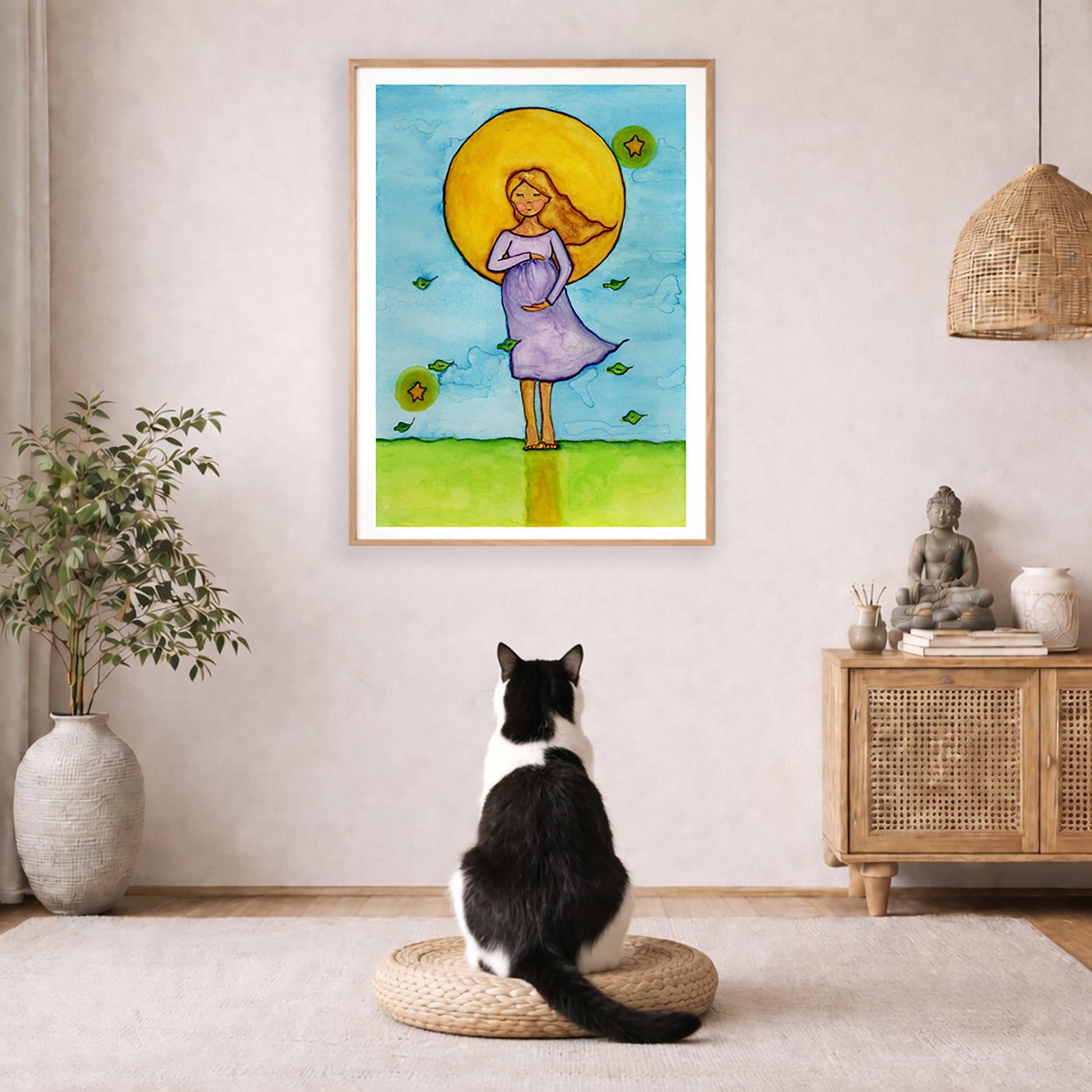 Woman standing in meditation under a glowing sun with blue sky background, calming watercolor spiritual illustration.  The poster is framed and is in the center of the living room wall. A black and white cat is staring at the poster. There is a potted plant on the left side and a cabinet with a Buddha statue on it on the right side. 
