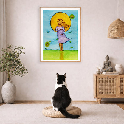 Woman standing in meditation under a glowing sun with blue sky background, calming watercolor spiritual illustration.  The poster is framed and is in the center of the living room wall. A black and white cat is staring at the poster. There is a potted plant on the left side and a cabinet with a Buddha statue on it on the right side. 
