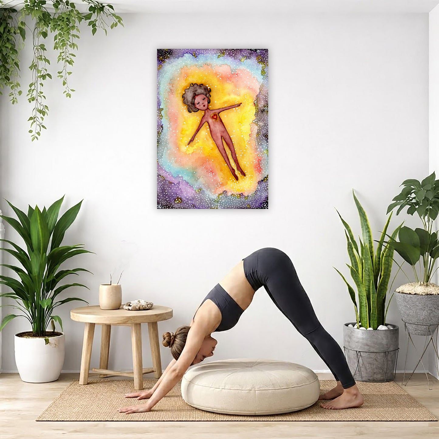 Astral body travelling in another dimension canvas poster. The poster is framed and is in the center of the living room wall. Below the poster a woman is doing the yoga posture downward facing dog on a wicker yoga mat.