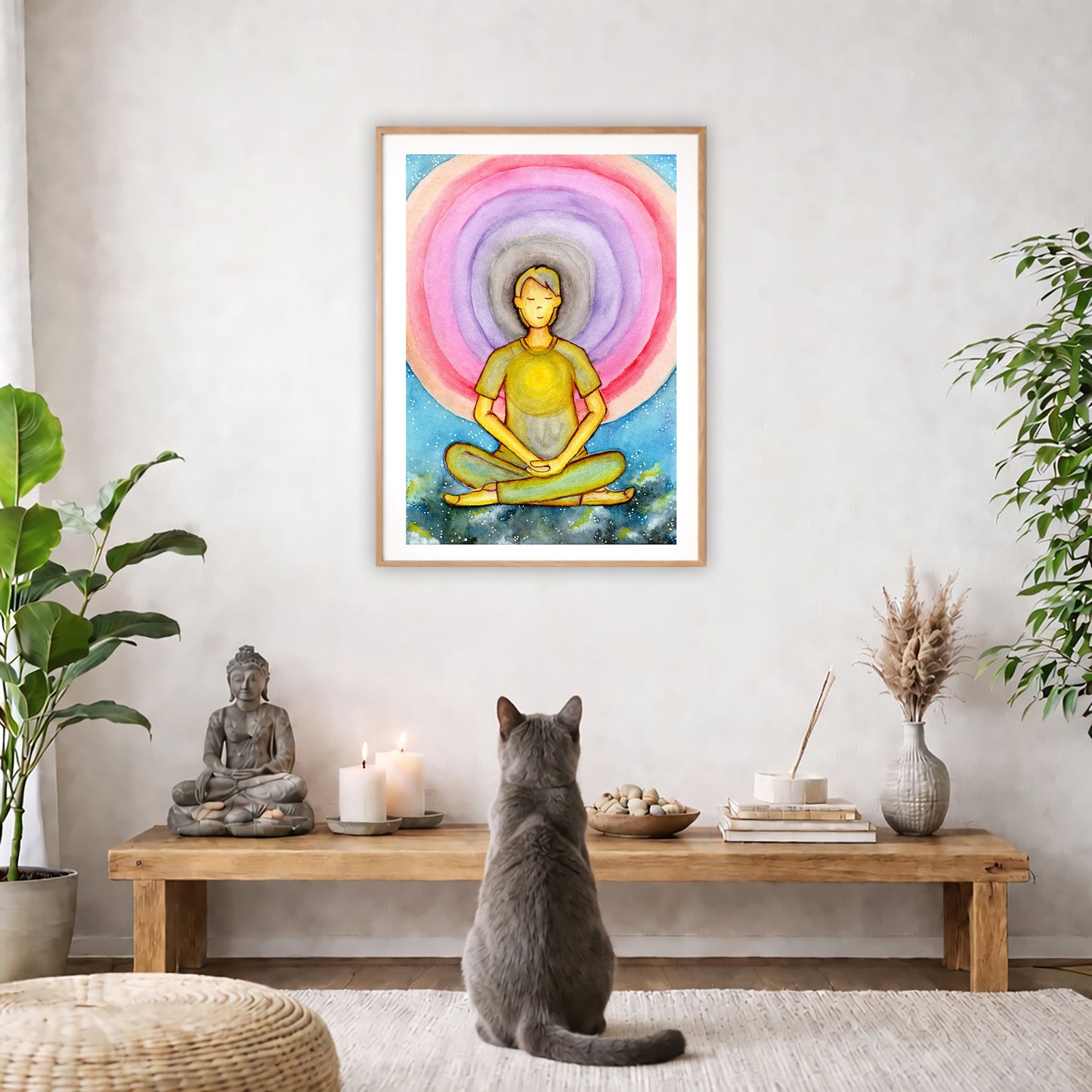 Poster of a young man's heart chakra glowing and aura energy flowing around him.  The poster is in the center of the living room wall. A gray cat is facing the poster. In front of it is a coffee table with a Buddha statue and burning candle on the left and incense and an orange cat staring at the poster on the right. There is a green potted plant on both the left and right side of the coffee table.