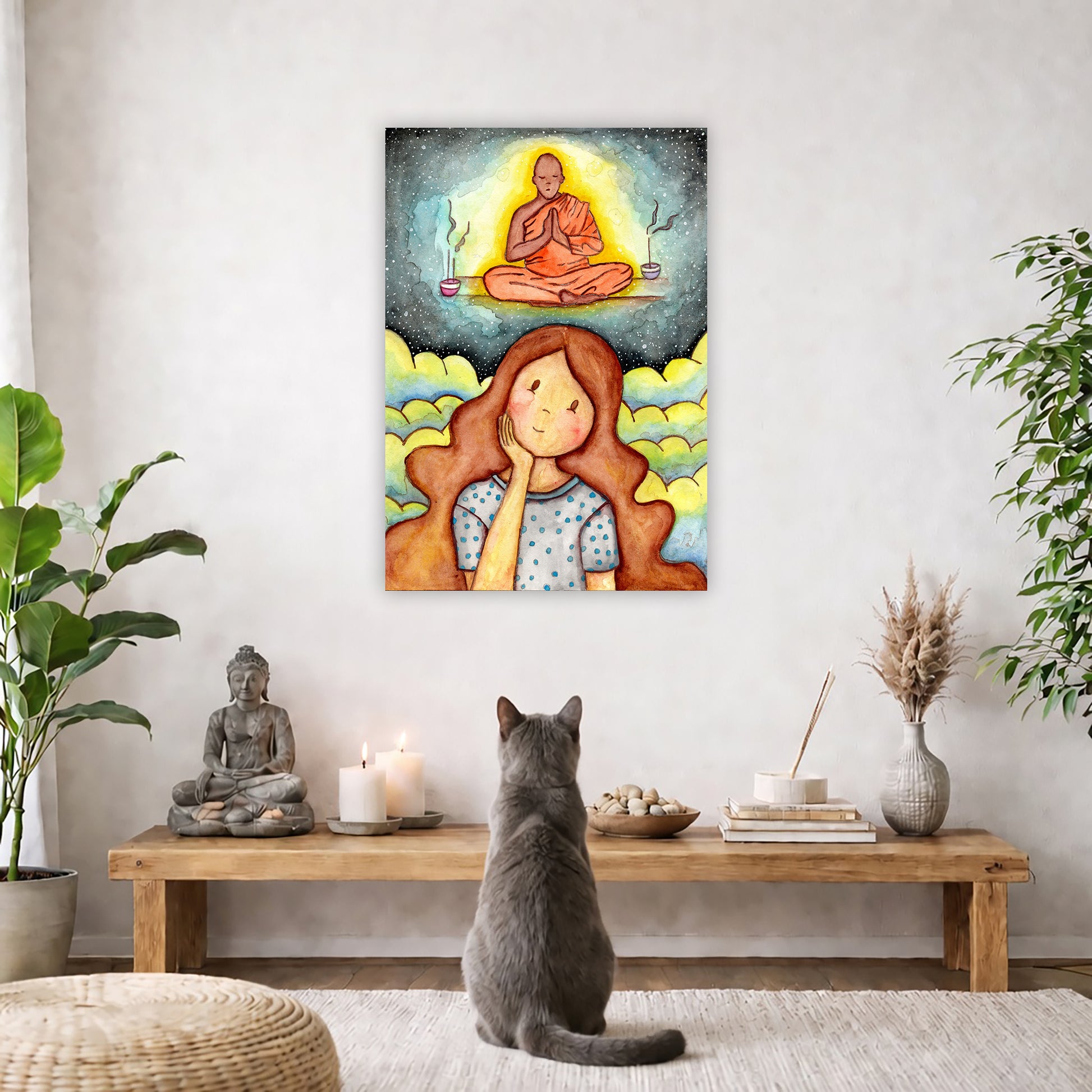 Poster of woman imagining the higher power that will guide her as she learns to meditate. The poster is framed and is in the center of the living room wall. A gray cat is facing the poster. In front of it is a coffee table with a Buddha statue and burning candle on the left and incense and an orange cat staring at the poster on the right. There is a green potted plant on both the left and right side of the coffee table.