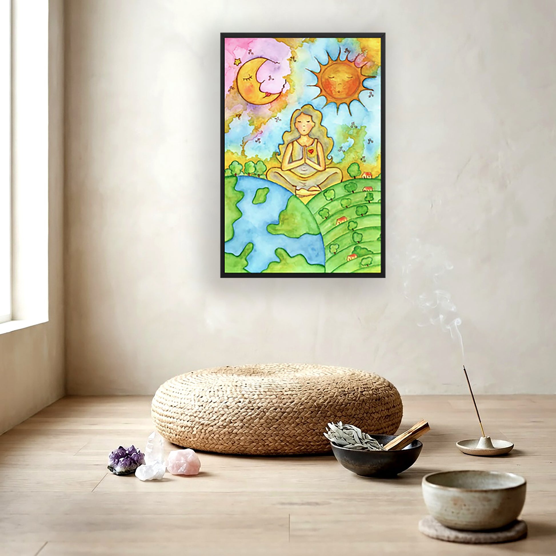 Poster of a woman meditating beneath the sun and moon in a cosmic design. The poster is framed and is in the center of the living room wall. To the left of the poster is a window. Below the poster is a large wicker cushion. On the floor there is a collection of crystals, a Tibetan bowl and burning incense.