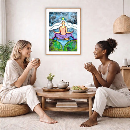 Poster of a woman meditating on three worlds with her crown chakra glowing.  The poster is in the center of the living room wall. Two female friends are having tea, grapes and cookies on a coffee table in front of the poster. On the left there is a green potted plant and to the right there is a hanging lamp.
