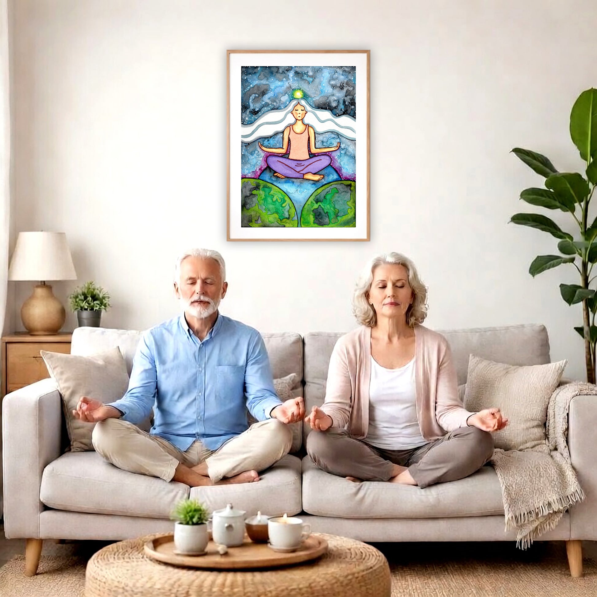 Poster of a woman meditating on three worlds with her crown chakra glowing.  A couple is meditating on their couch. The poster is framed on a wall behind them. There is a coffee table in front with candles burning and a potted plant. There is a potted plant to the right and shelves on the left.
