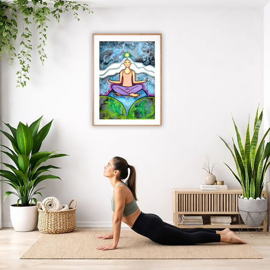 Poster of a woman meditating on three worlds with her crown chakra glowing.  The poster is hanging on the wall. A woman on her yoga mat is doing the cobra pose in front of the poster. There is a potted plant and a hanging plant on the left side. A padded bench with material draped over it is behind her. On the right side are two potted plants.

