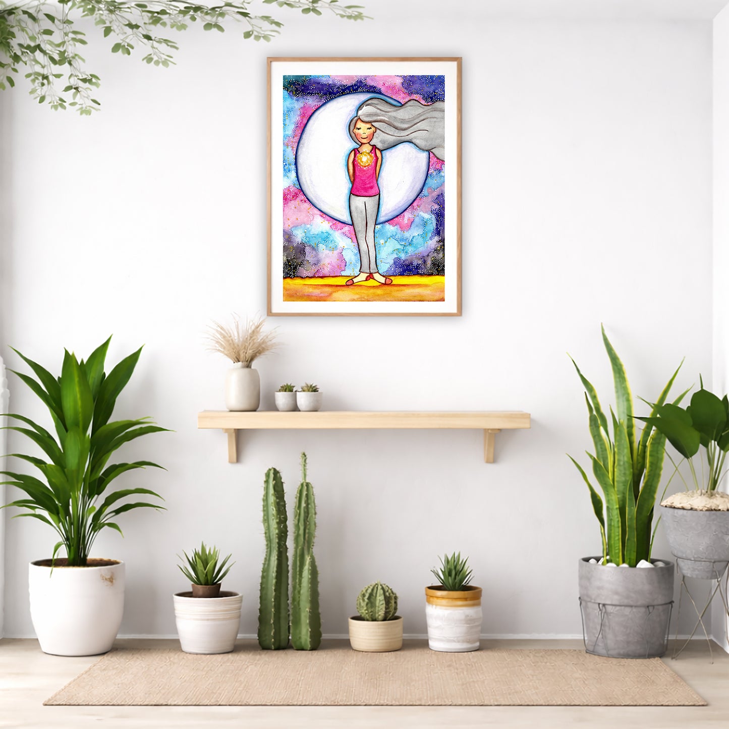 Poster of a woman's heart chakra glowing with love energy.  The poster is in the center of the living room wall. Below the poster is an empty bench. Below the bench is a variety of green potted plants including a few cactus.
