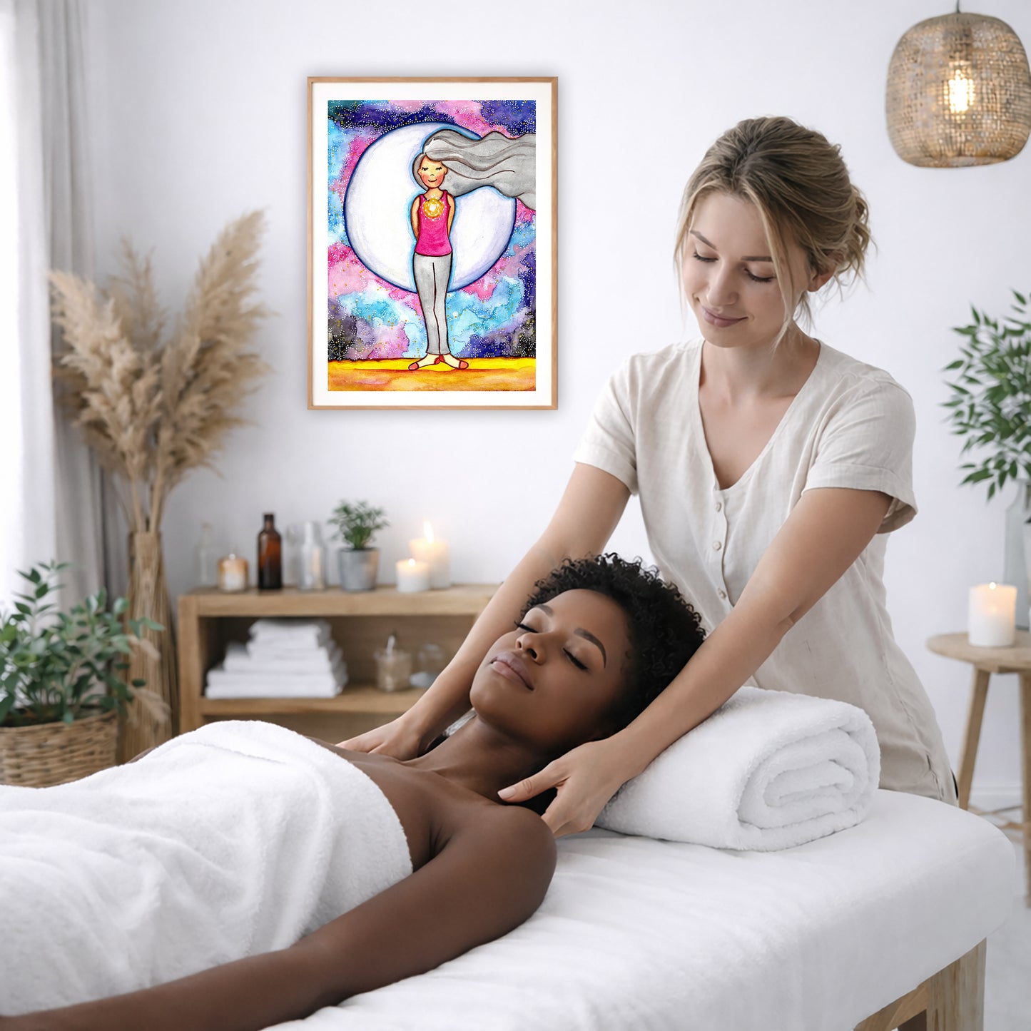 Poster of a woman's heart chakra glowing with love energy. The poster is on the wall of the office of a massage therapist. The therapist is giving her female client a massage. The client is lying face up on a massage table. The client is wearing a white towel. To the left is a window, a floor plant and a large vase of dry flora. There is shelf underneath the poster with candles burning. There is also a candle burning on a small table on the right side. There is a hanging lamp with a wicker shade.