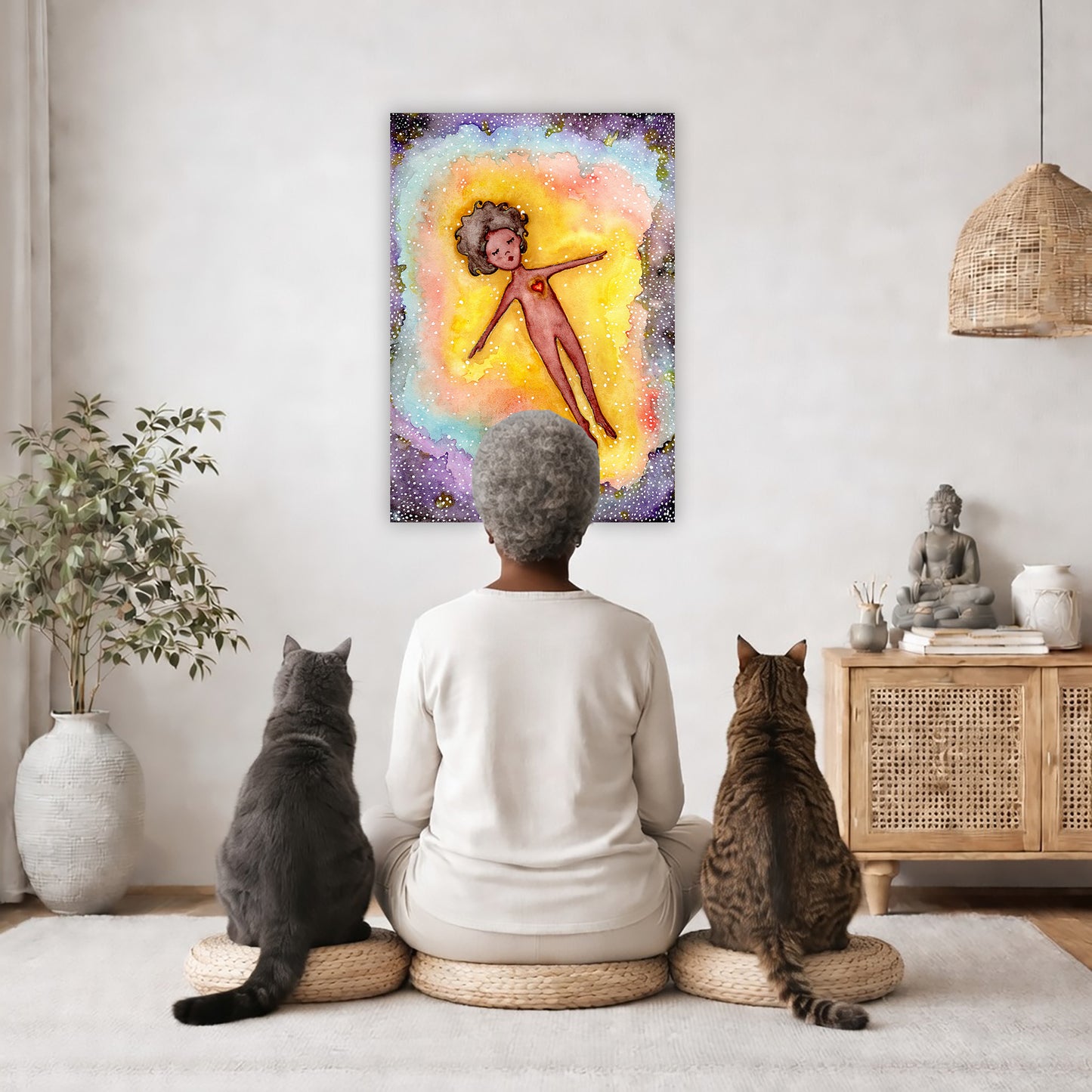 Astral body travelling in another dimension canvas poster.  The poster is framed and is in the center of the living room wall. A woman is meditating facing the poster with a white cat on her left side and a black cat on her right side. There is a potted plant on the left side and a cabinet with a Buddha statue on it on the right side. 