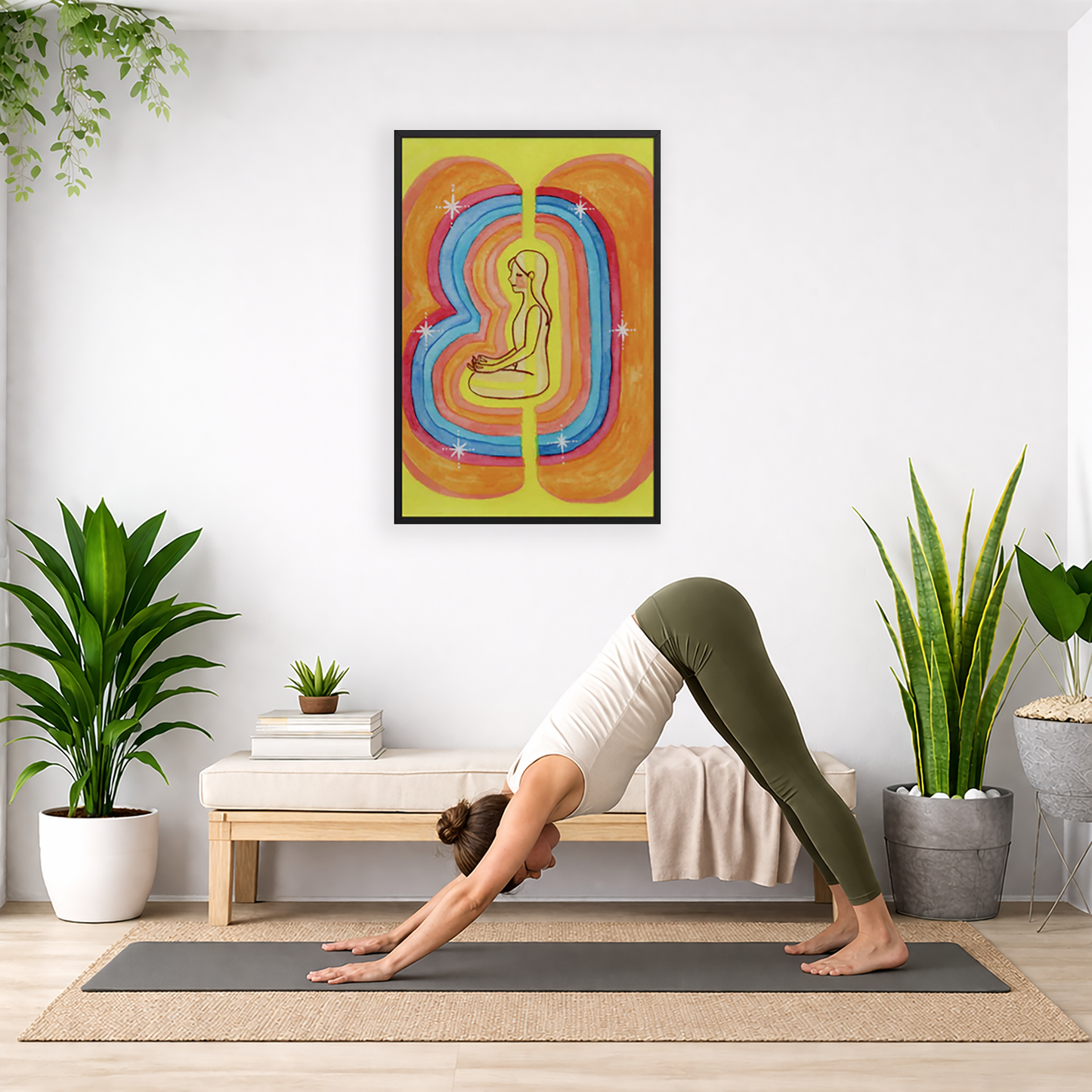 Rainbow aura energy field portrait on mindfulness framed poster.  The poster is framed and is in the center of the living room wall. Below the poster a woman is doing the yoga posture downward facing dog on a wicker yoga mat.