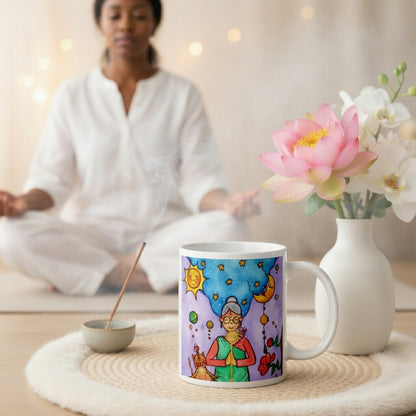 Woman and her cat meditating under sun and moon, peaceful scene representing harmony, balance and connection, spiritual coffee mug design.  The mug is sitting on a white mat with flowers and burning incense beside it. A woman is meditating in the background.