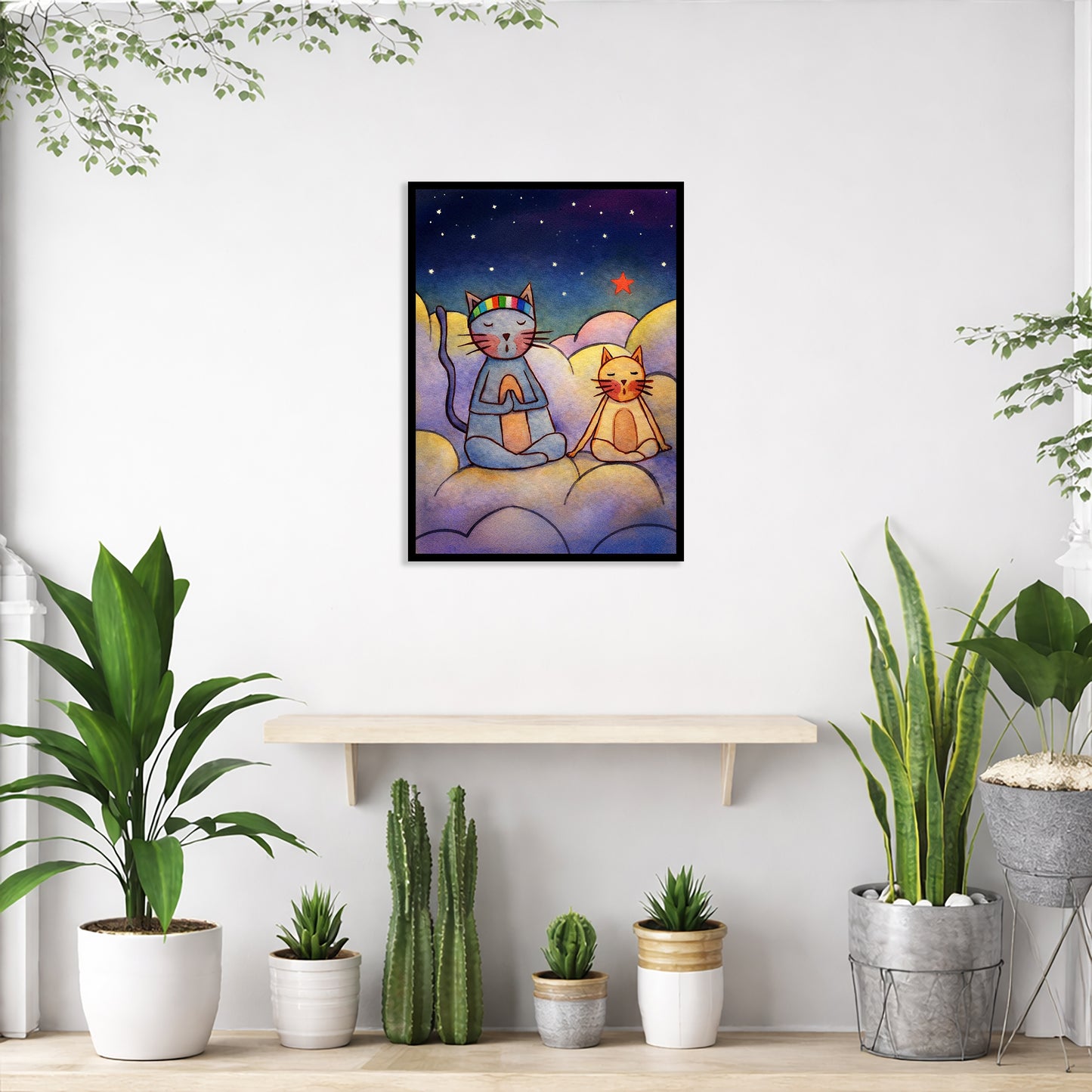 Two cats meditating on a cloud at night under the stars framed poster. This is a print of the original illustration by Brazilian artist Thaís Suizo. The poster is in the center of the living room wall. Below the poster is an empty bench. Below the bench is a variety of green potted plants including a few cactus.
