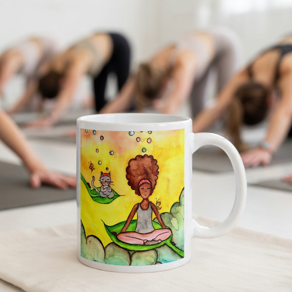 Woman and cat sitting peacefully on leaves in meditation, nature-inspired mindfulness scene representing calm, balance and connection, printed on a spiritual coffee mug.  The mug is in front of a yoga class doing the downward facing dog posture.