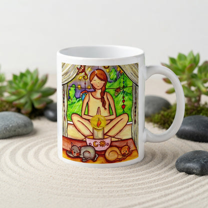 Candlelight trataka meditation design on mindfulness mug. Two cats are sleeping in front of the lady as she meditates.  The mug is in a beautifully raked zen garden with bushes and plants behind it.