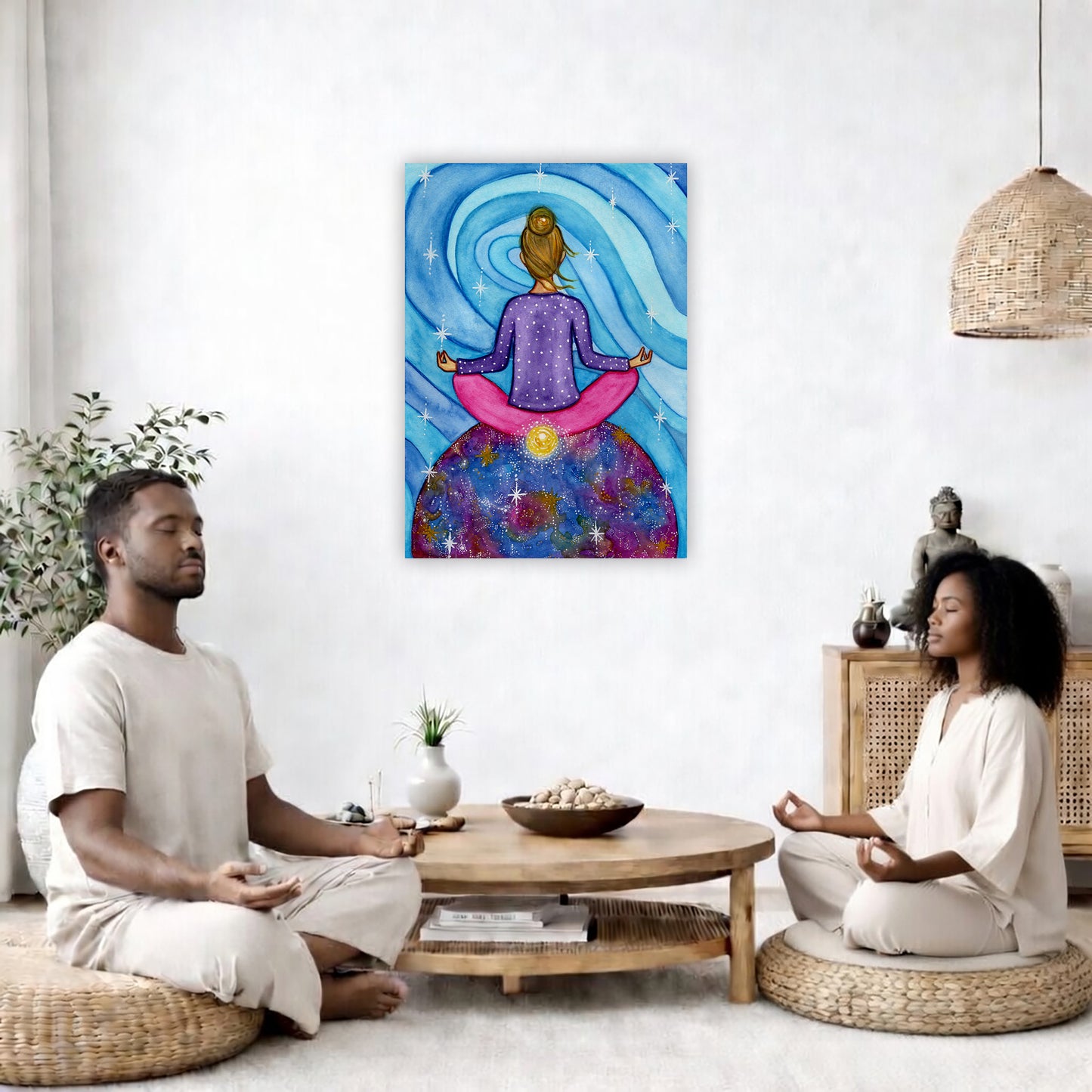 Canvas of a woman meditating with her root chakra glowing. This is a print of the original hand-painted watercolor by Brazilian artist Thaís Suizo for the LET'S MEDITATE SERIES of mediation guides.  The poster is in the center of the living room wall. Two friends are sitting on wicker pillows meditating. Between them is a small round coffee table with incense, a green potted plant and a bowl of shells. There is a potted plant to the left and a Buddha statue and a vase to the right. 