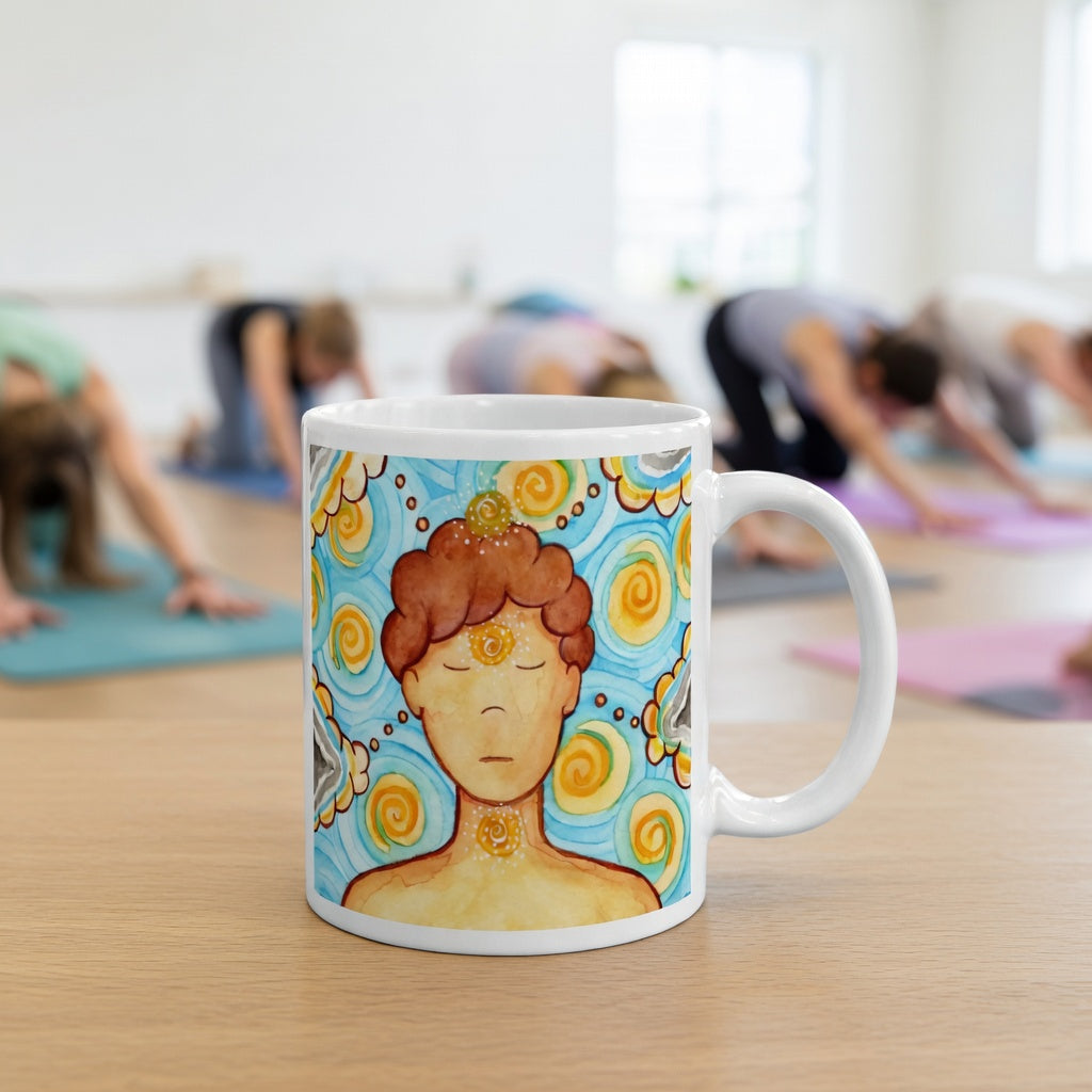 Man meditating with glowing throat, brow and crown chakras, symbolizing communication, intuition and spiritual connection, chakra artwork on a coffee mug. The mug is in front of a yoga class doing the downward facing dog posture.