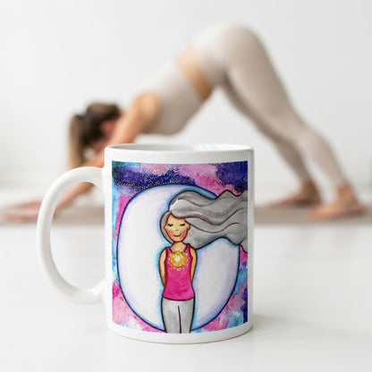 Meditating person with glowing heart chakra at center of chest, symbolizing love, compassion and emotional balance, spiritual design on a mindfulness coffee mug.  The mug is in front of a woman doing the yoga posture downward facing dog.