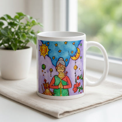 Woman and her cat meditating under sun and moon, peaceful scene representing harmony, balance and connection, spiritual coffee mug design. The mug is sitting on a white cloth. There is a window, curtains and a green potted plant behind the mug.