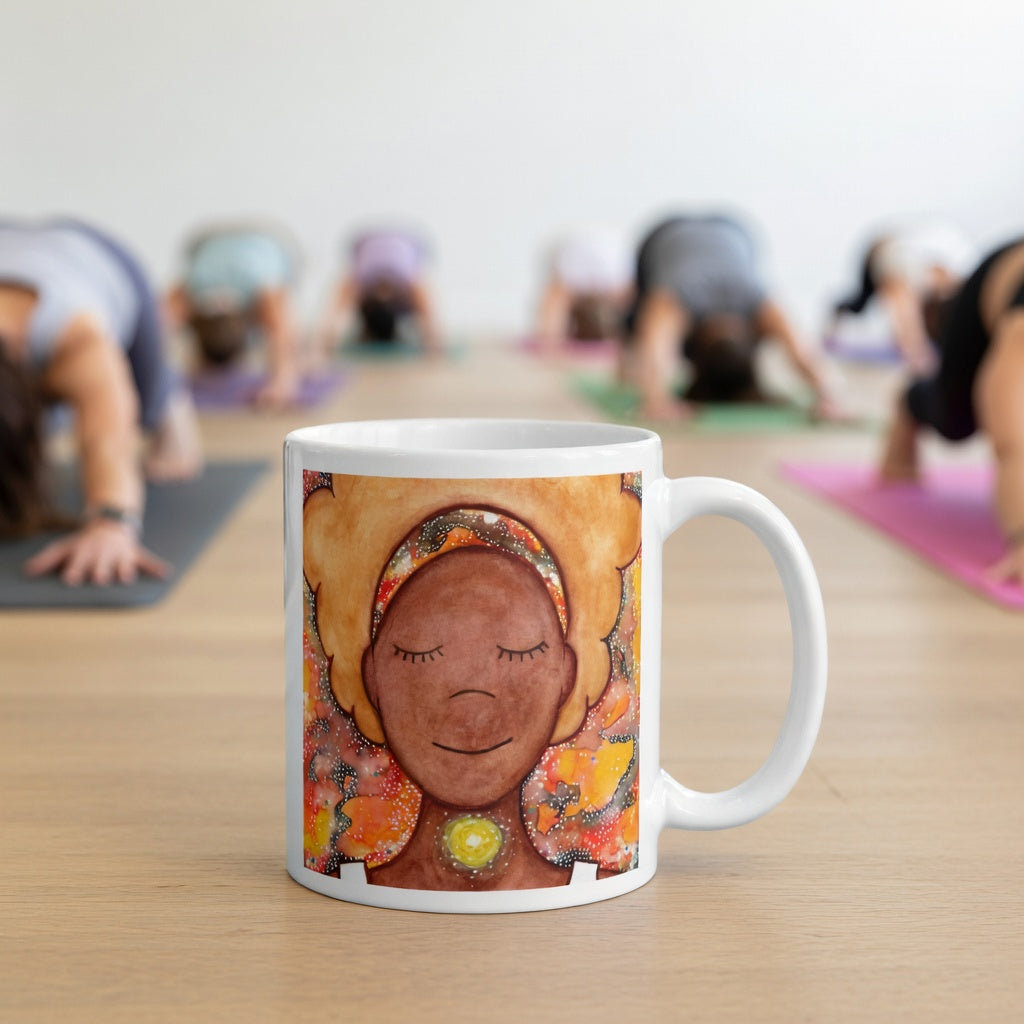 Meditating figure with glowing throat chakra, symbolizing communication, truth and self-expression, spiritual mindfulness artwork on a coffee mug.  The mug is in front of a yoga class doing the downward facing dog posture.