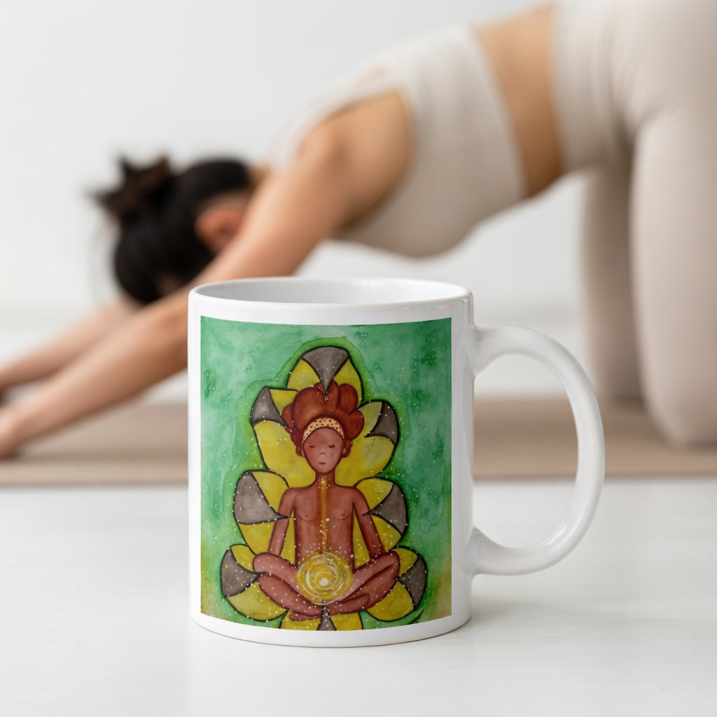 Meditating figure with glowing sacral chakra below the navel, representing creativity, passion and emotional flow, spiritual chakra artwork on a coffee mug.  The mug is in front of a woman doing the yoga posture downward facing dog.